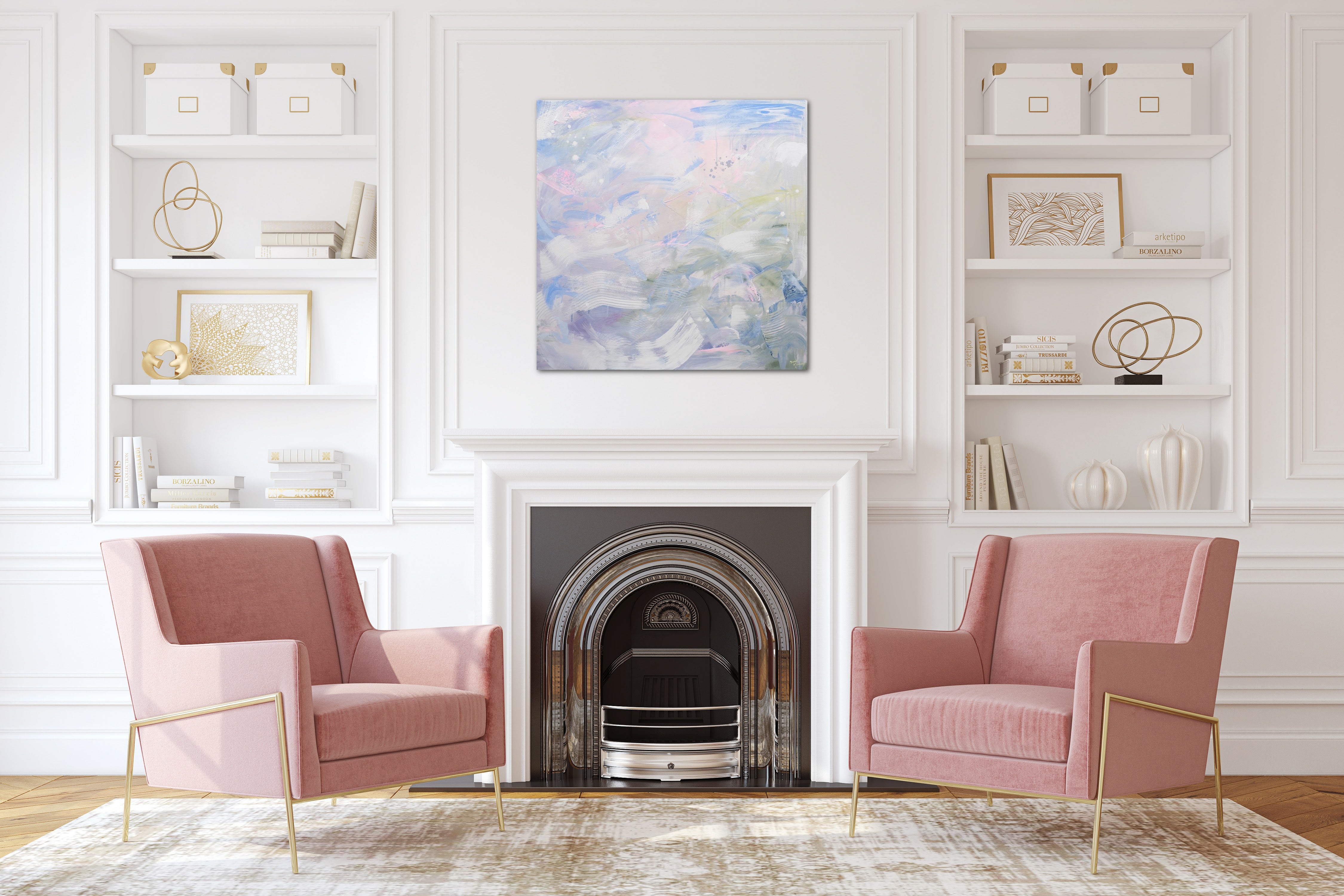 A pastel painting on canvas hangs above a classical fireplace in a traditional modern living room.  Two pink chairs flank the fireplace and styled built in shelving displays decor objects. 